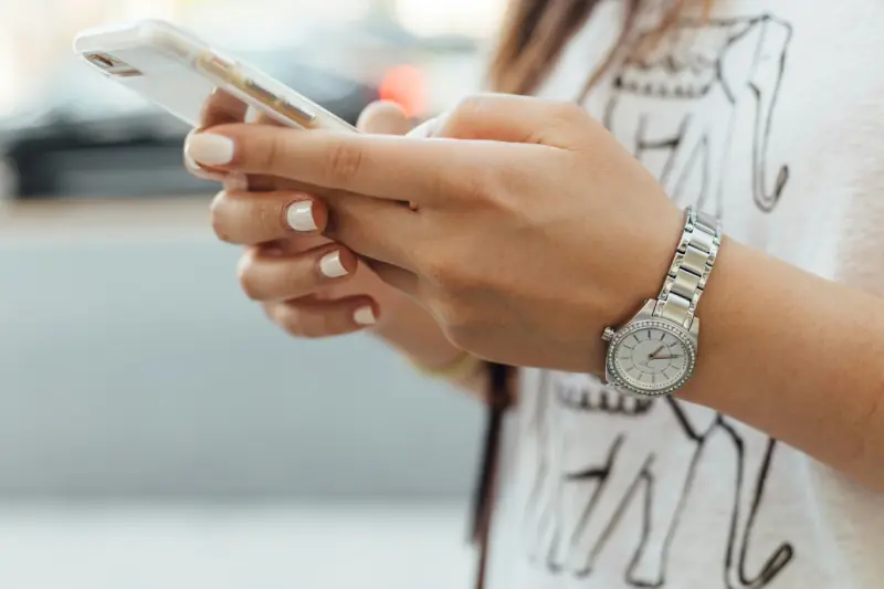 A hand texting on a mobile phone contacting Thrive Inside CIC